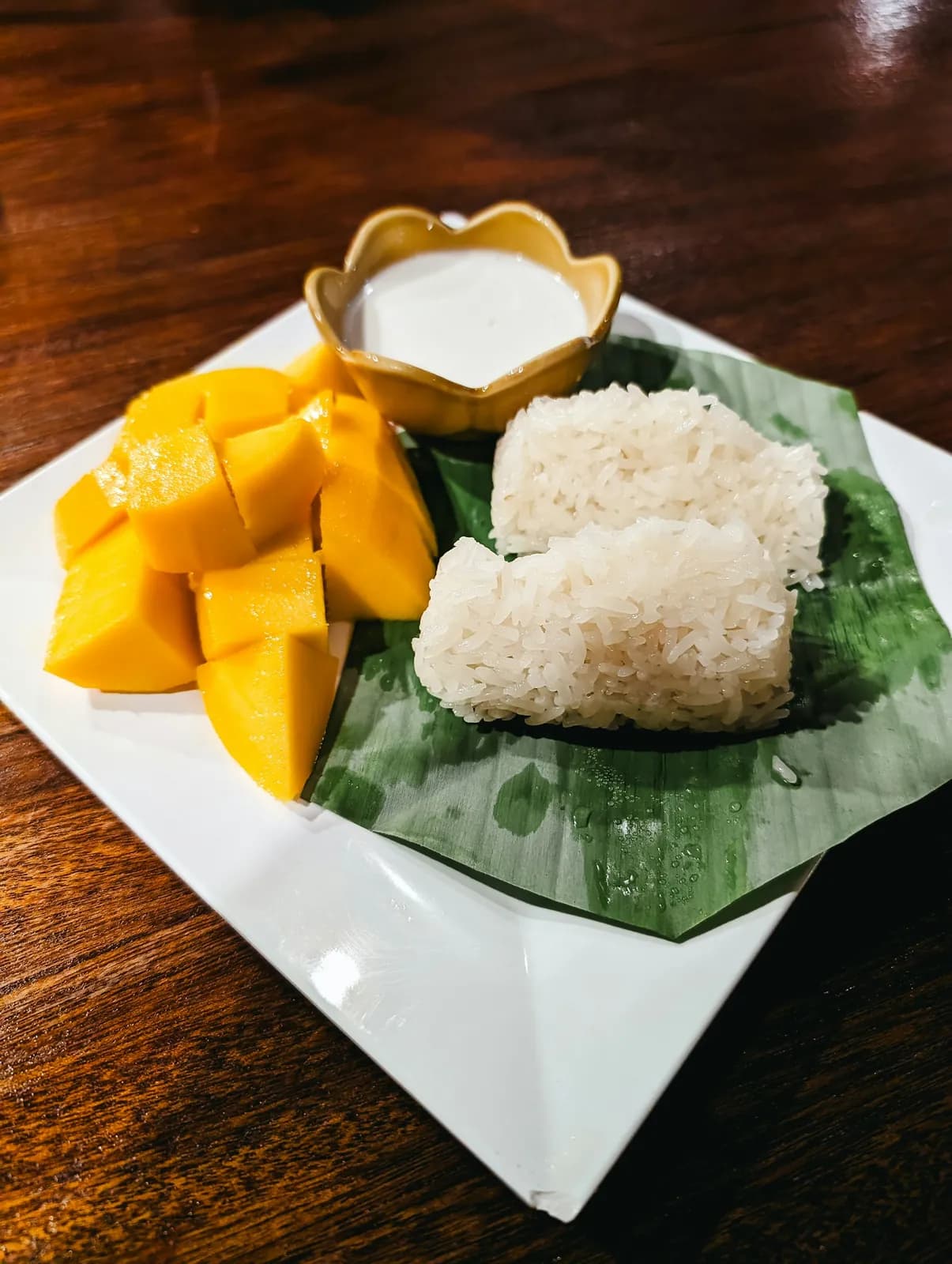 ข้าวเหนียวมะม่วงบนใบตอง กับกะทิในถ้วยเล็ก