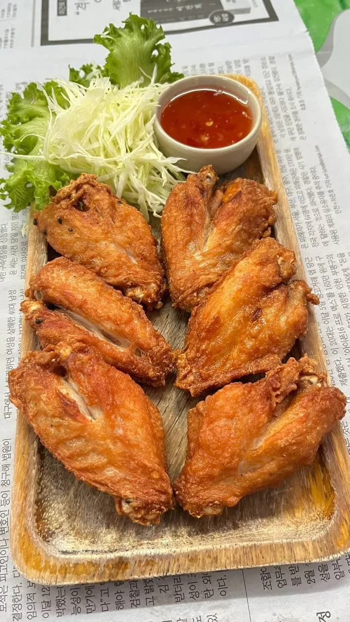 ปีกไก่ทอดบนถาดไม้ กับกะหล่ำและน้ำจิ้ม